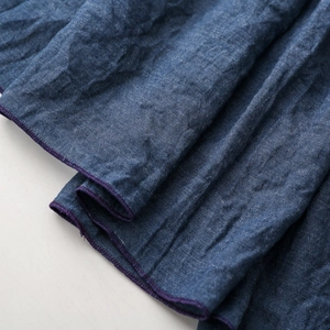 Nahaufnahme von blauem Baumwoll-Leinen-Schal mit lila Naht und weicher Textur