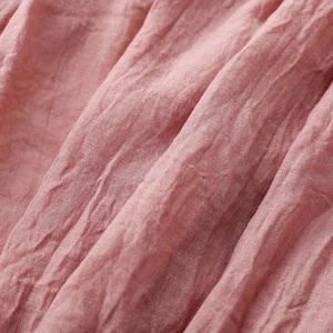 Nahaufnahme von rosa Baumwoll-Leinen-Schal mit weicher Faltenstruktur und Webdetail