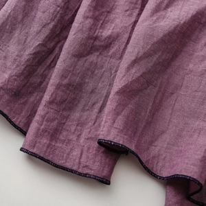Makro-Detail des pflaumenlila Leinen-Baumwoll-Stoffs mit Textur und feiner Naht
