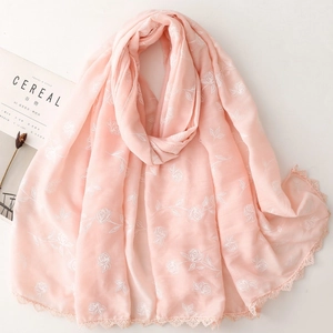 Écharpe rose clair avec broderie de roses et bordures en dentelle sur fond blanc