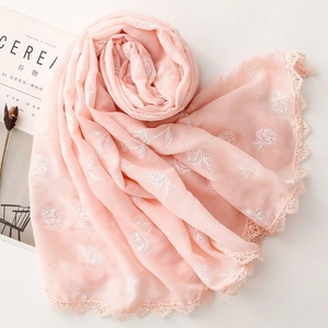 Détail de l'écharpe rose en coton et lin avec broderie rose et bordure dentelle