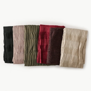Detailed view of pleated fabric texture on scarves in multiple fashion colors