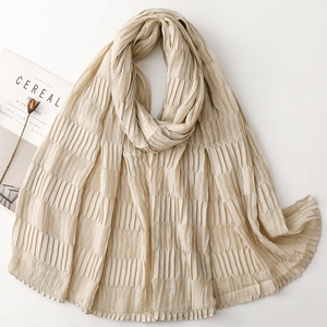 Close-up of beige pleated scarf texture with elegant vertical accordion folds