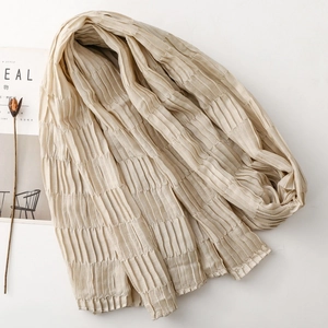 Detailed close-up of apricot pleated scarf with vertical accordion texture on white background