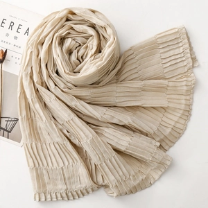 Detailed macro shot of pleated texture on a soft beige scarf with wavy edges