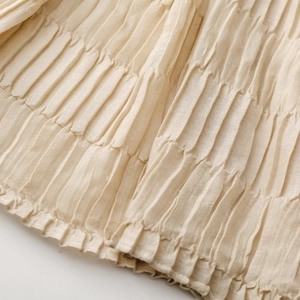 Macro view of textured pleated fabric detail in beige with soft rippled fabric texture