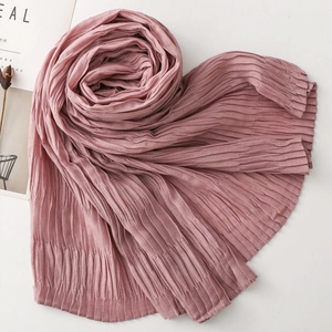 Detail shot of dusty pink pleated scarf fabric texture with artistic spiral fold styling