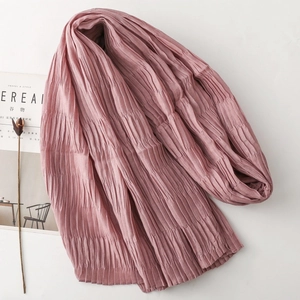 Close-up of textured pleated scarf in dusty rose with soft wavy edges and fine fabric