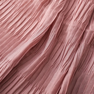 Detailed macro shot of elegant dusty rose pleated fabric with fine textured vertical folds
