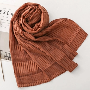 Detail of brown pleated scarf with textured fabric and elegant vertical wrinkles