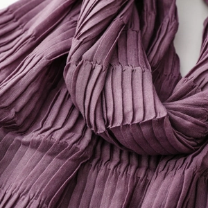 Macro detail of pleated texture and soft silk-like fabric on this deep purple scarf