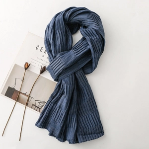 Detail of dark blue pleated scarf showing fine texture and vertical accordion folds