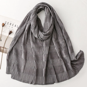 Detail of dark grey pleated scarf showing intricate vertical texture and soft crinkle fabric