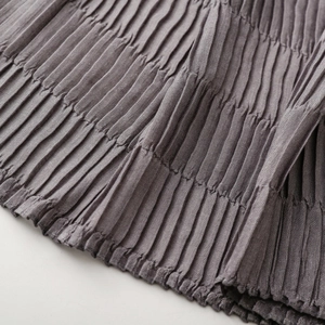 Detailed macro view of fine pleated texture on soft grey autumn winter scarf fabric