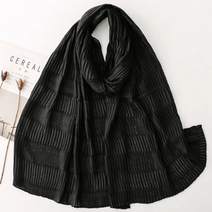 Detail of black pleated scarf showing rich crinkle texture and soft elegant fabric draping