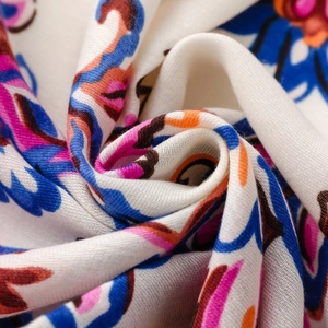 Macro shot of ethnic floral pattern on soft bohemian shawl with colorful silk texture