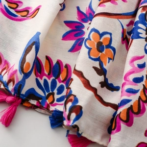 Close-up of bohemian floral scarf with vibrant fringe detailing and soft fabric texture