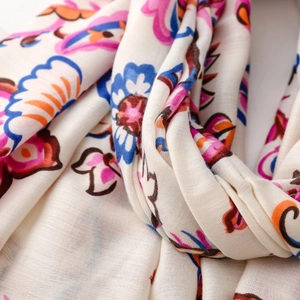 Macro detail of bohemian floral scarf showing soft cotton fabric and vibrant colorful patterns