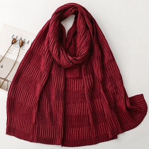 Detailed view of dark red pleated scarf with a wavy texture and elegant wavy edges