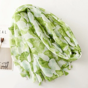 Elegant green ginkgo leaf print scarf with tassels on breathable white linen fabric