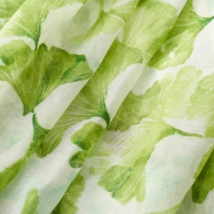 Close-up of green ginkgo leaf print on lightweight cotton linen fabric texture