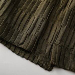Detailed macro view of the olive green pleated texture on a soft winter scarf fabric