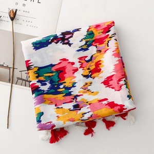 Detail of artistic graffiti print shawl with vibrant colors and soft decorative tassels