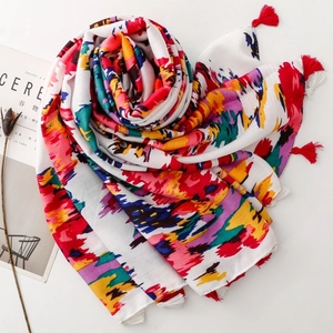 Close-up of artistic graffiti printed scarf with red tassels and stylish dried flowers