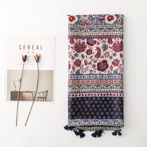 Ethnic bohemian shawl with geometric floral print and tassels on a white background