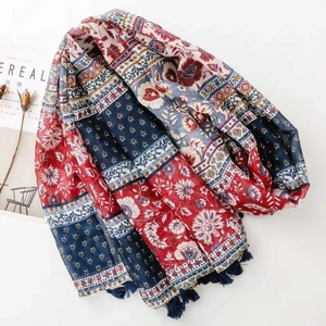 Close-up of bohemian floral print scarf with navy blue tassels and geometric borders