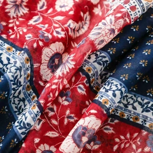Close-up of bohemian floral print fabric with deep red and navy blue woven texture