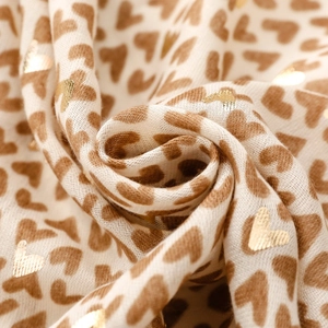 Close-up of lightweight off-white scarf with gold foil and brown heart patterns