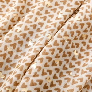 Close-up of heart print scarf with gold foil accents on beige chiffon fabric