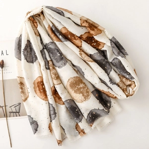 Détail d'une écharpe en coton et lin avec pois aquarelle et accents dorés élégants