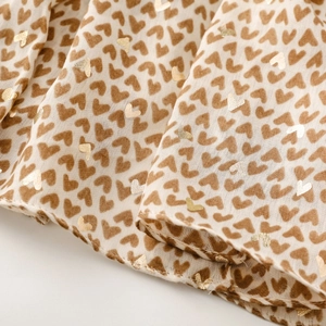Close-up of heart print scarf fabric with gold foil details and soft textures