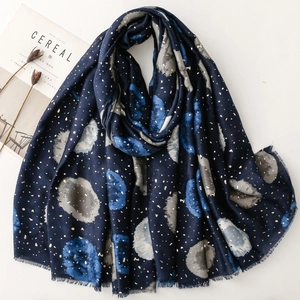 Écharpe en lin bleu foncé avec pois dorés et franges sur un bureau minimaliste