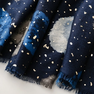 Détail d'écharpe en coton et lin bleu marine avec pois dorés et bords à franges