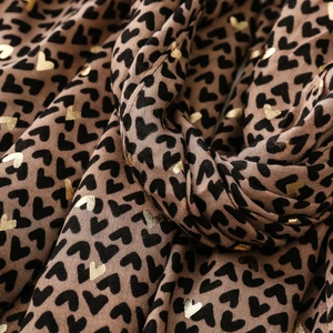 Detail of brown scarf with black heart prints and golden foil heart accents