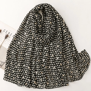 Elegant black shawl with gold and white heart prints, styled with minimalist magazine