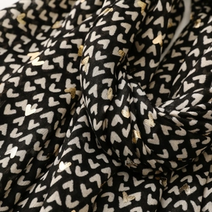 Detail of heart print scarf showing golden foil texture and soft fabric drapes