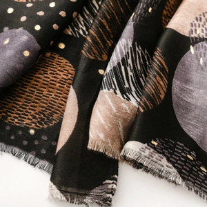 Detail von Baumwoll-Leinen-Schal mit goldenem Mond-Druck und weichen Fransen am Rand