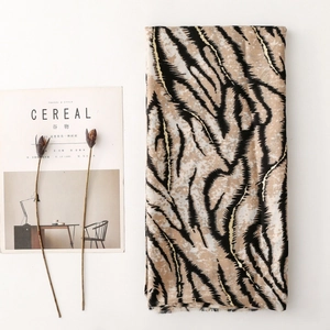 Detail shot of linen-feel zebra tiger print scarf with frayed edges and soft texture