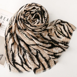 Detail of tiger print scarf with gold metallic threads and natural frayed edges