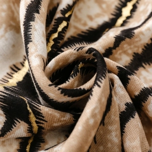 Macro detail of zebra print scarf fabric with metallic gold thread and soft texture