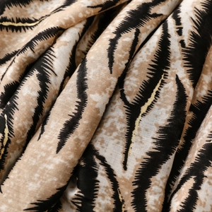 Detail of zebra print scarf with gold foil accents and soft cotton-linen texture