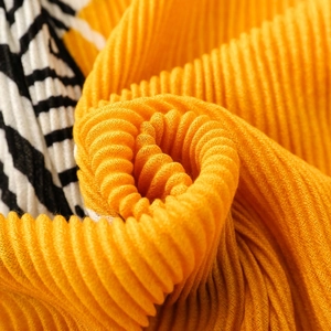 Pleated scarf with bright orange fabric and black-white zebra stripes in macro view