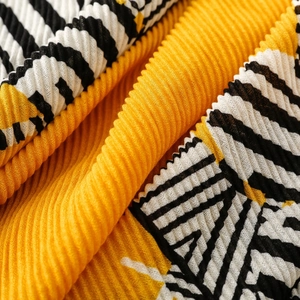 Macro shot of yellow and black zebra stripe pleated scarf showing fine plissé fabric texture