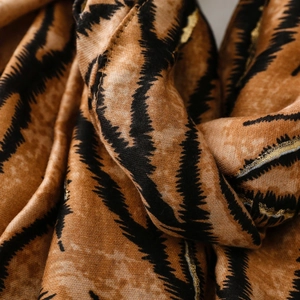 Detail of zebra pattern scarf with golden lurex thread and soft fringe texture