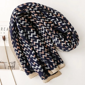 Pleated navy blue scarf with geometric chevron pattern shown in minimalist setting