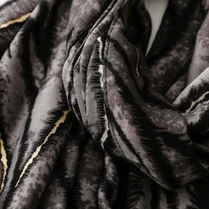Detail shot of zebra print scarf showing metallic gold foil and soft fabric texture
